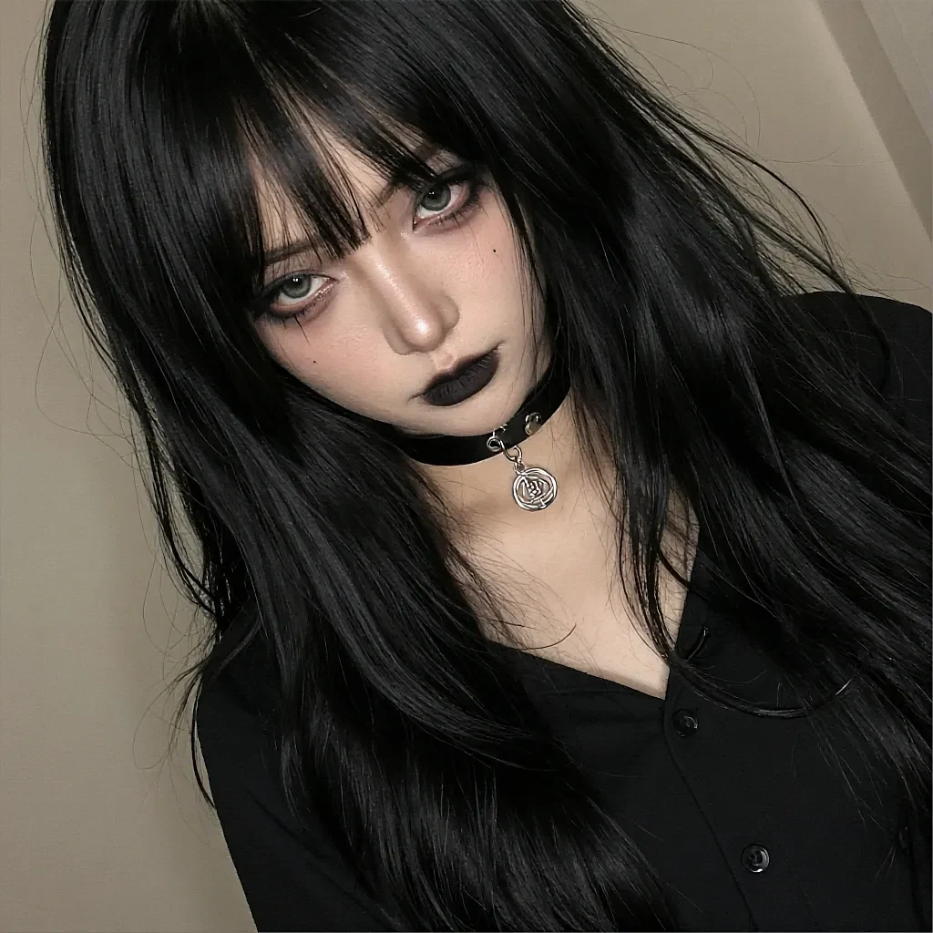 Black-haired woman with bangs and dark lipstick in a black shirt with a leather choker and silver pendant